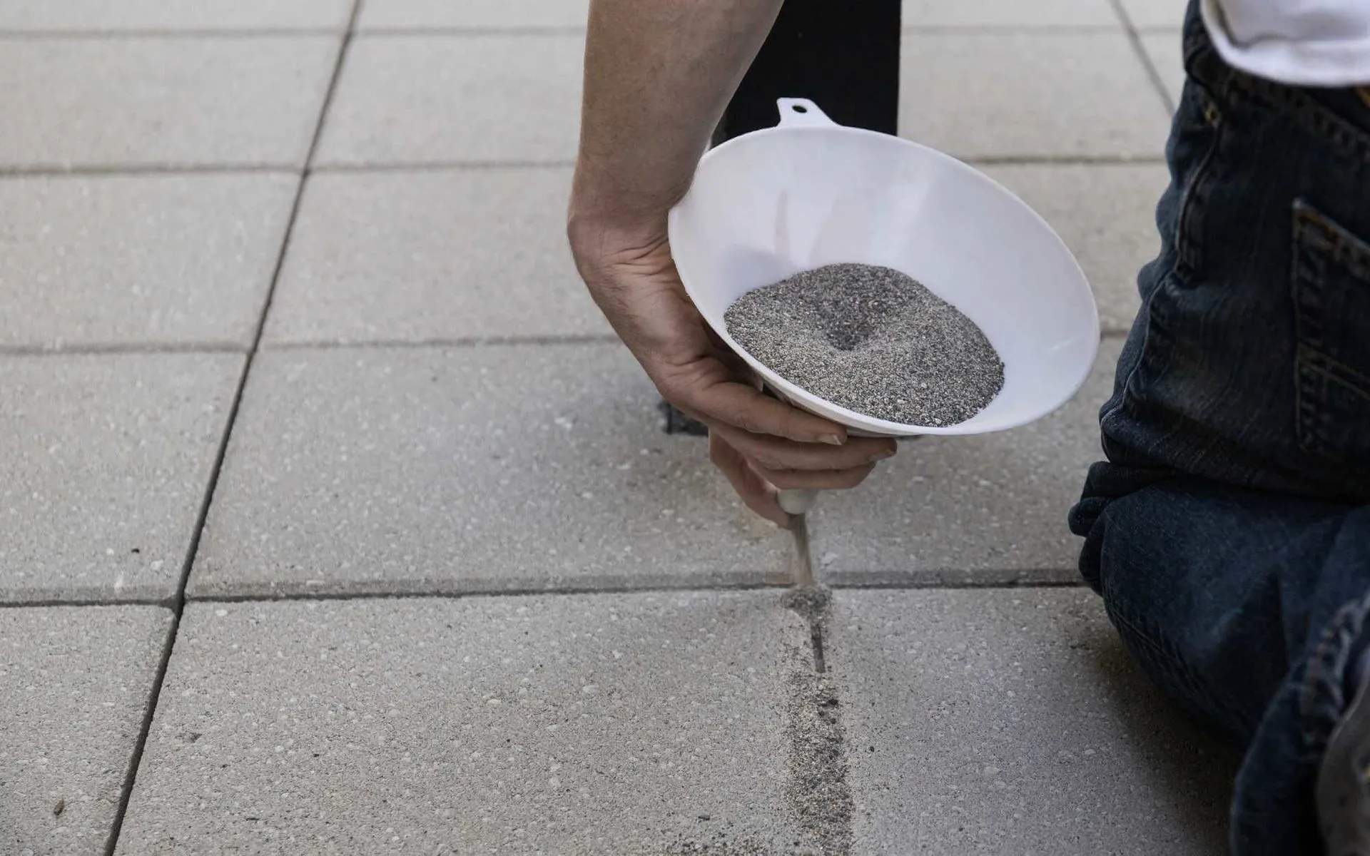 contractor applying joint sand between the pavers